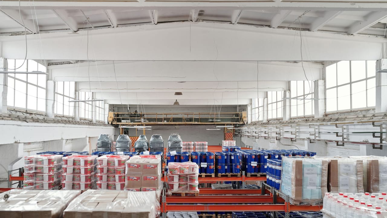 Staff documenting medical assets on a clipboard in an equipment logistics area.