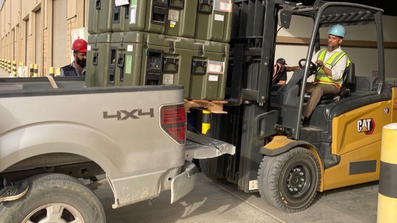 Equipment loaded and removed by a crew with a forklift and transport vehicle.