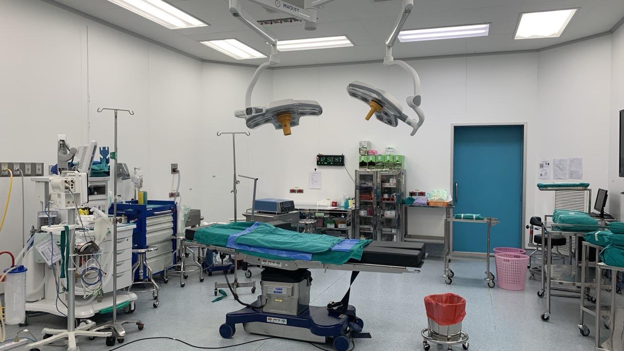 A modern operating room with surgical lights, table, and equipment before decommissioning.