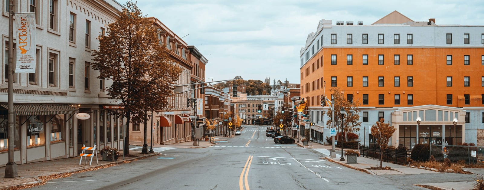 An empty street in downtown Bangor, Maine, lined with historic buildings
