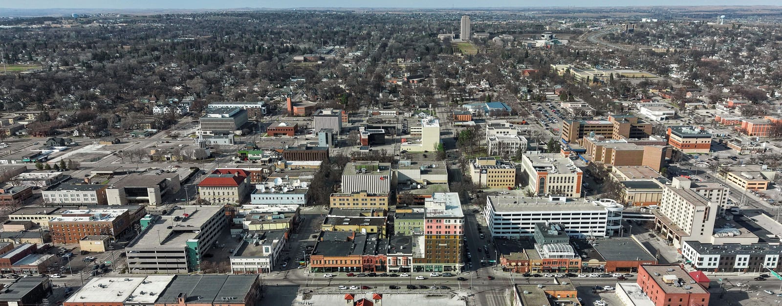 Aerial view of downtown Bismarck's blocks, with the North Dakota State Capitol tower in the distance