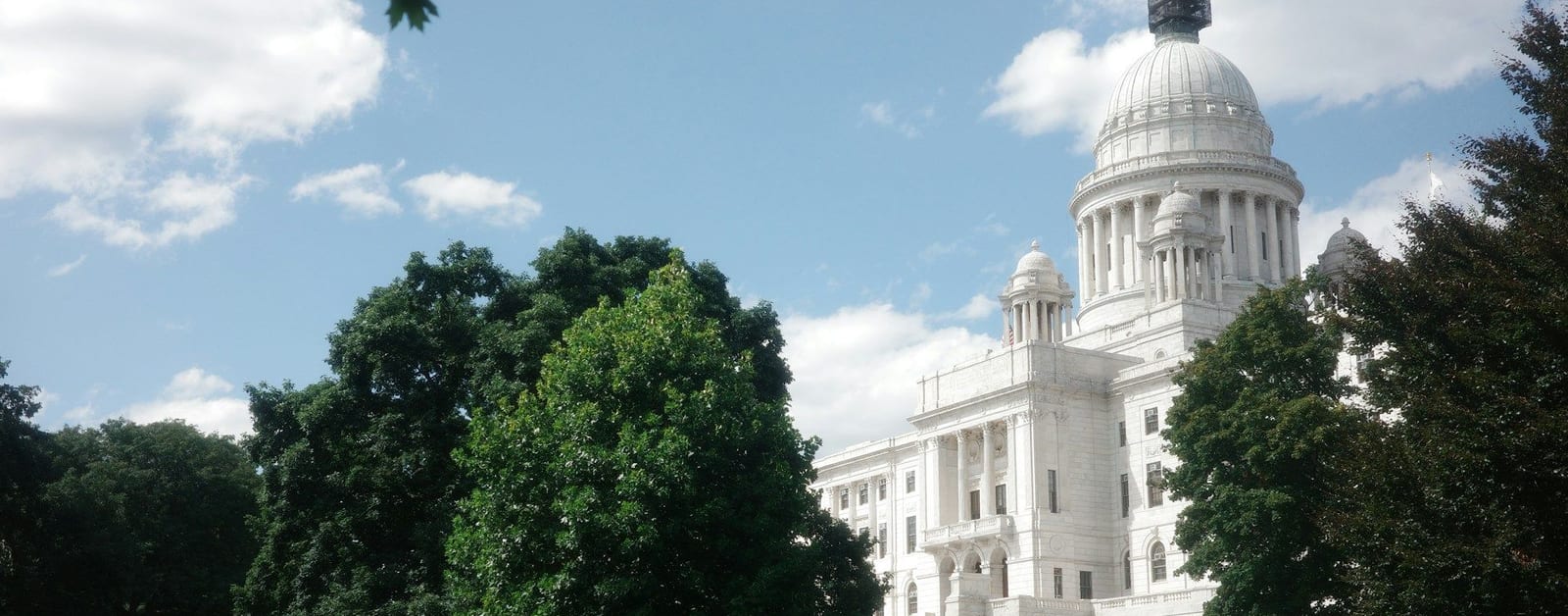 The Rhode Island State House dome above trees on the State House lawn in Providence