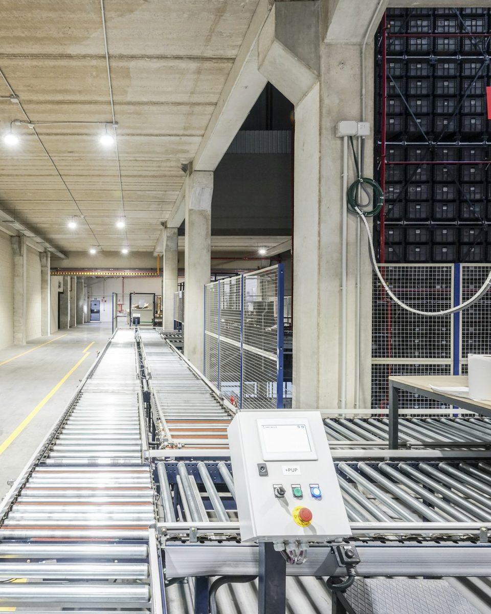 Roller conveyor running the length of an automated fulfillment corridor