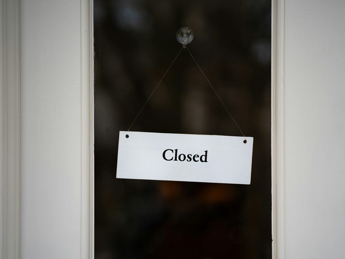Closed sign hanging inside a glass door