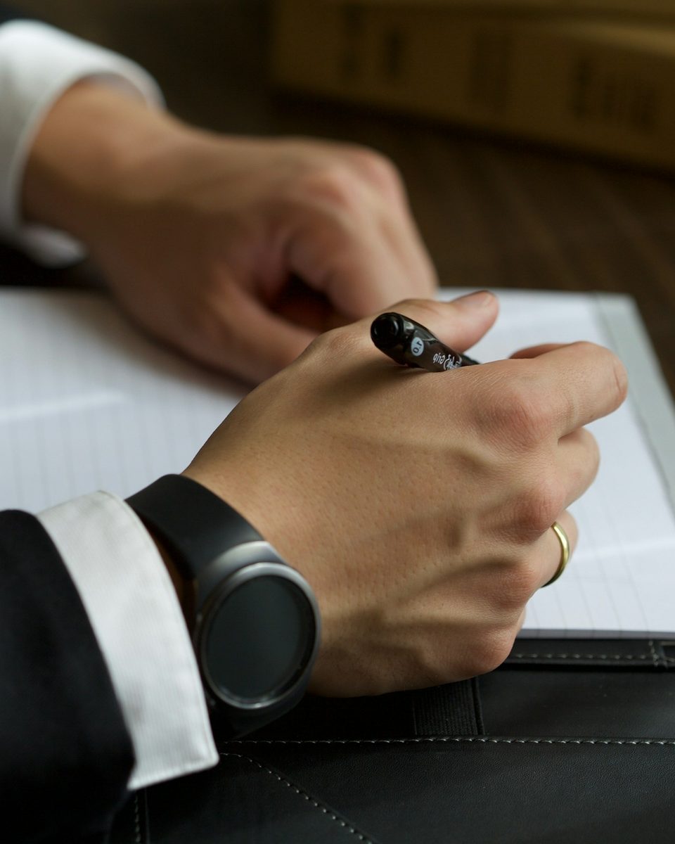Professional in a suit signing a document