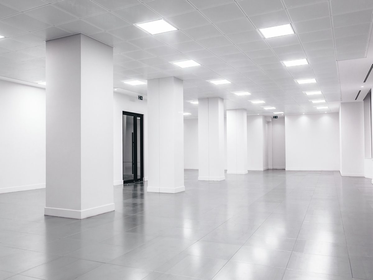 Empty, cleared commercial space under bright ceiling lights
