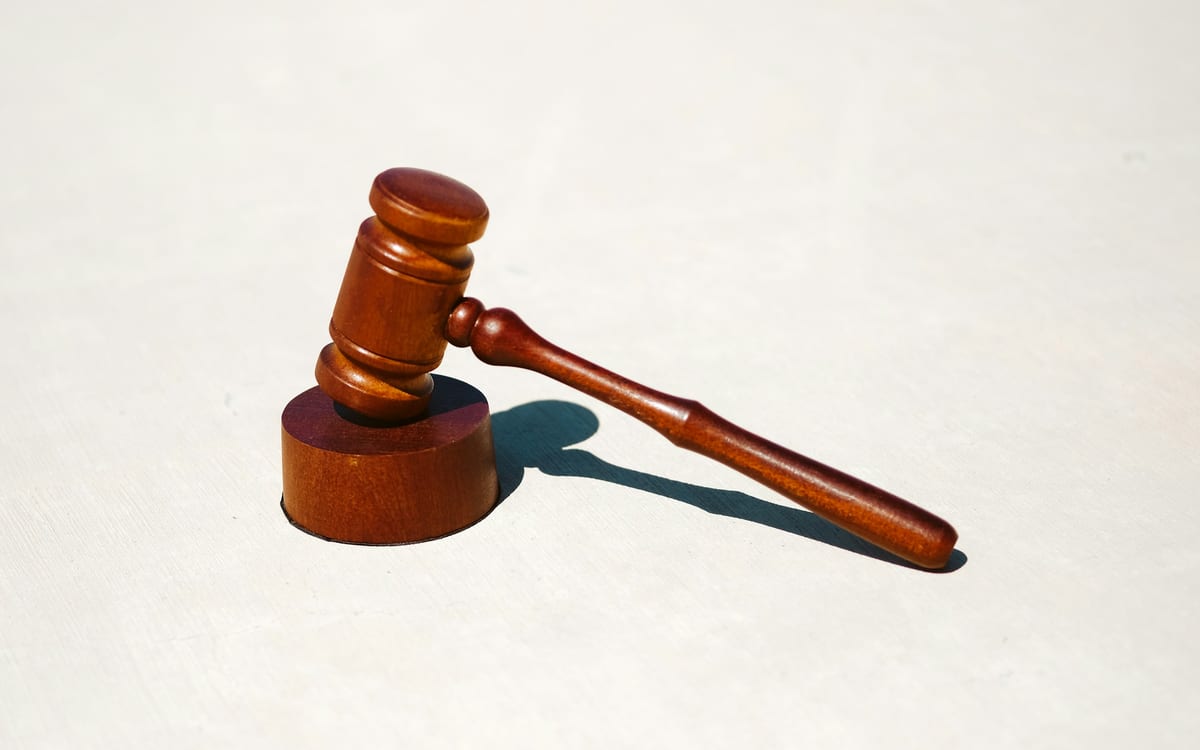 A wooden auction gavel on its sound block